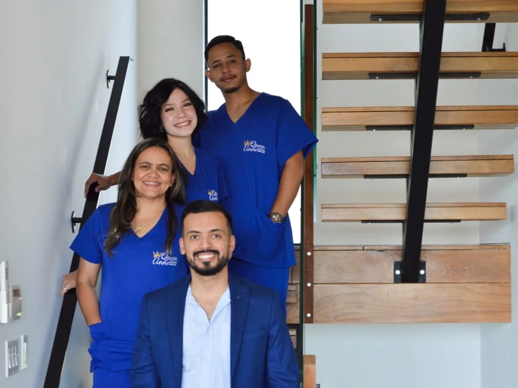 Four people pose on a staircase, three wearing blue medical scrubs and one in a blue blazer, reminiscent of a professional maid service team ready to take on any challenge.
